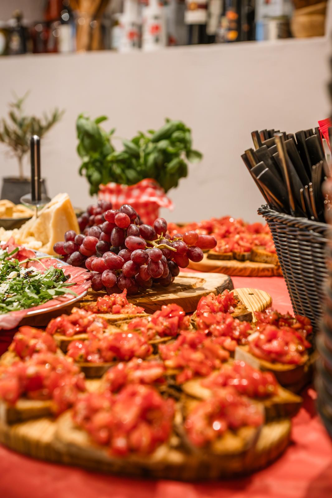 Bruschetta mit frischen Tomaten und Trauben auf Holzbrettern — Antipasti-Tafel bei Verace